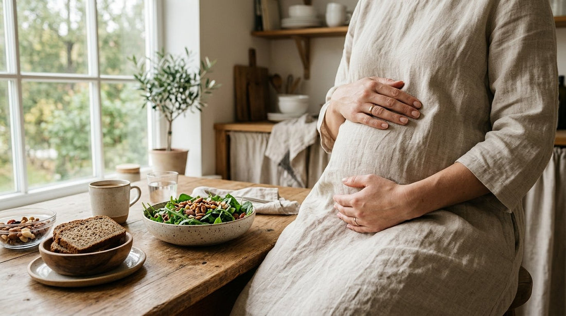 Gravid kvinnas händer vid ett bord med grönsaker, nötter och fullkornsbröd som ger magnesium.